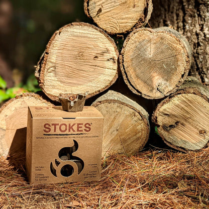 STOKES box in front of a stack of split firewood