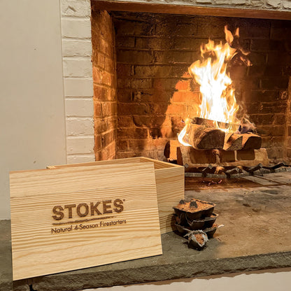 STOKES Fireside Box, pine box with the STOKES logo burned into the lid, beside a lit fireplace