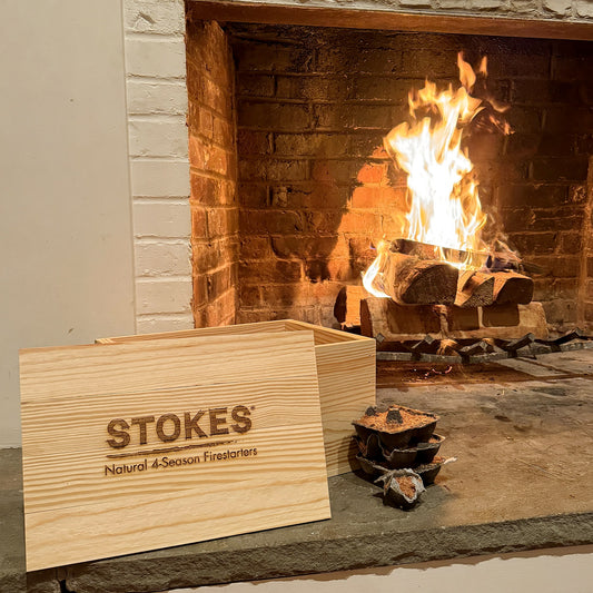 STOKES Fireside Box, pine box with the STOKES logo burned into the lid, beside a lit fireplace